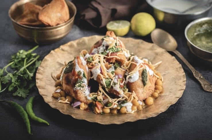 Samosa chaat topped with chutneys and sev
